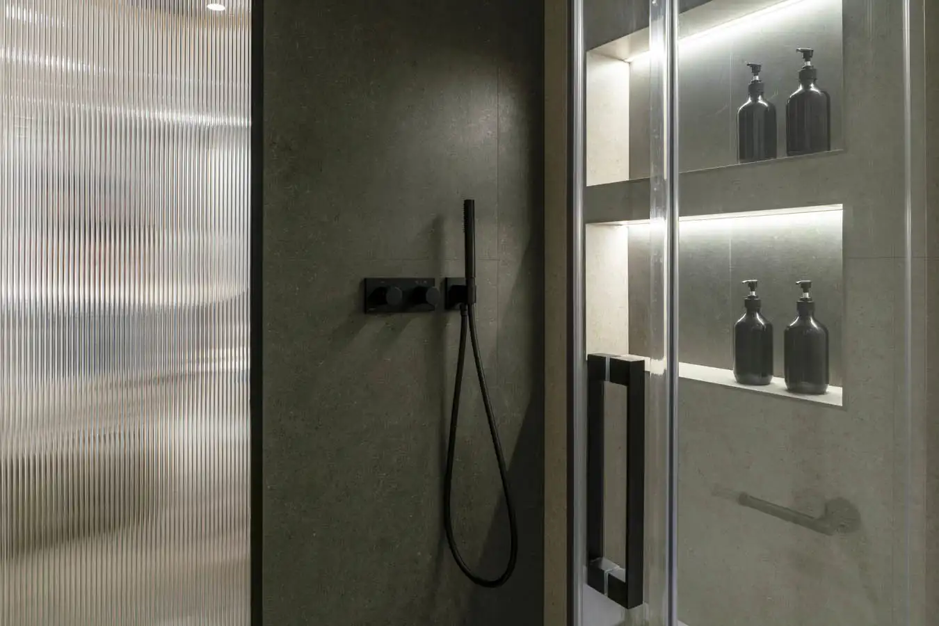Gracias a la iluminación instalada dentro de la ducha, la agradable luz que proporciona se traslada al dormitorio a través del cristal texturizado que los comunica.