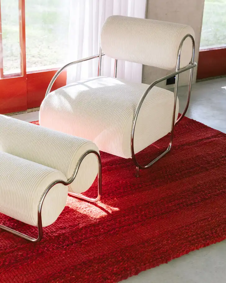 Sillón con reposapiés en alfombra roja 