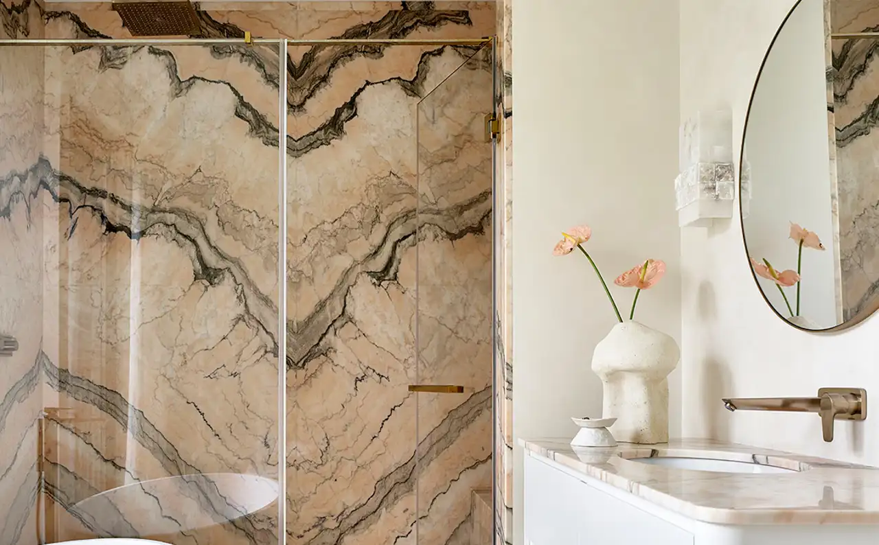 Baño blanco con ducha de mármol rosa