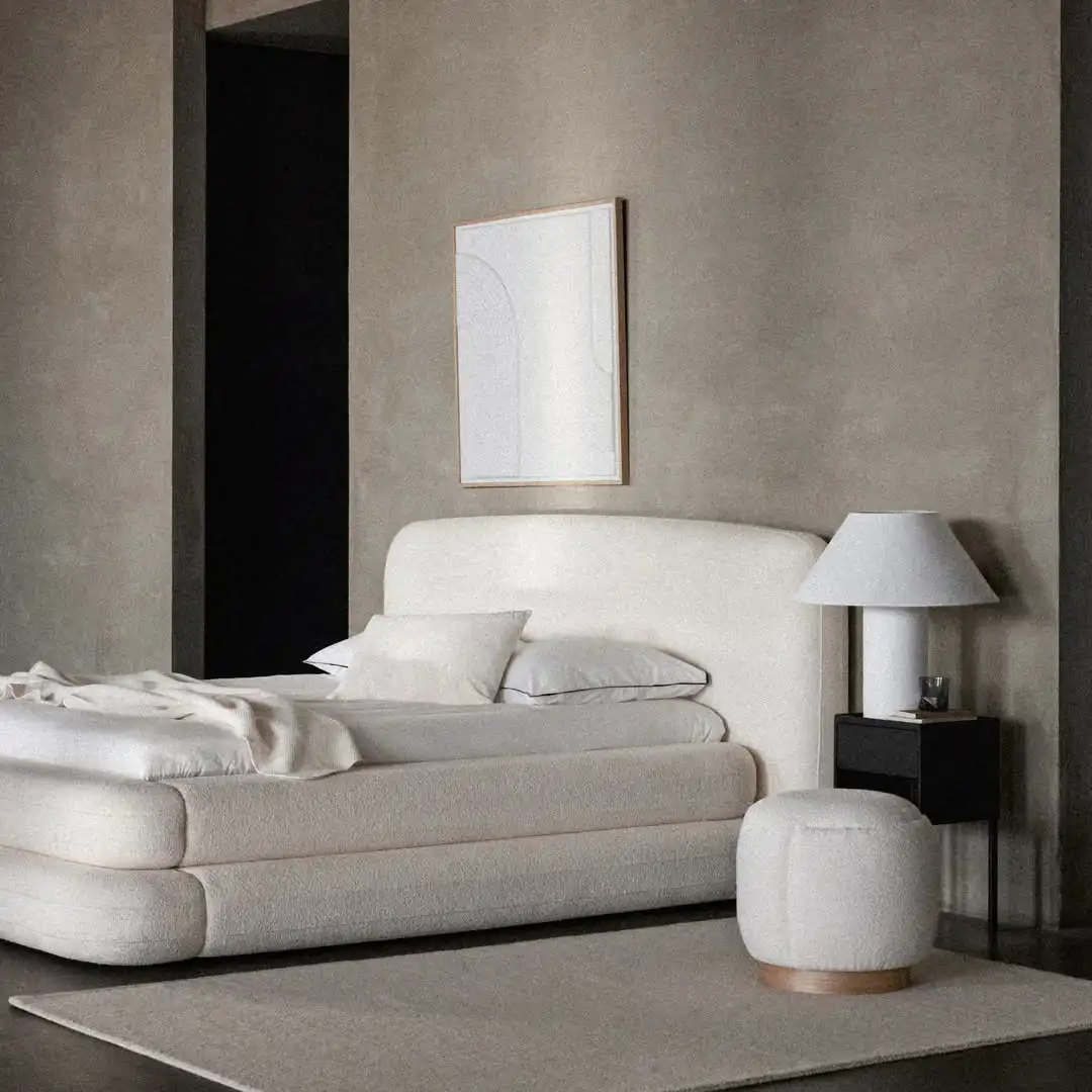 Dormitorio gris con cama en beige, puf blanoc y cabacero con cuadro blanco