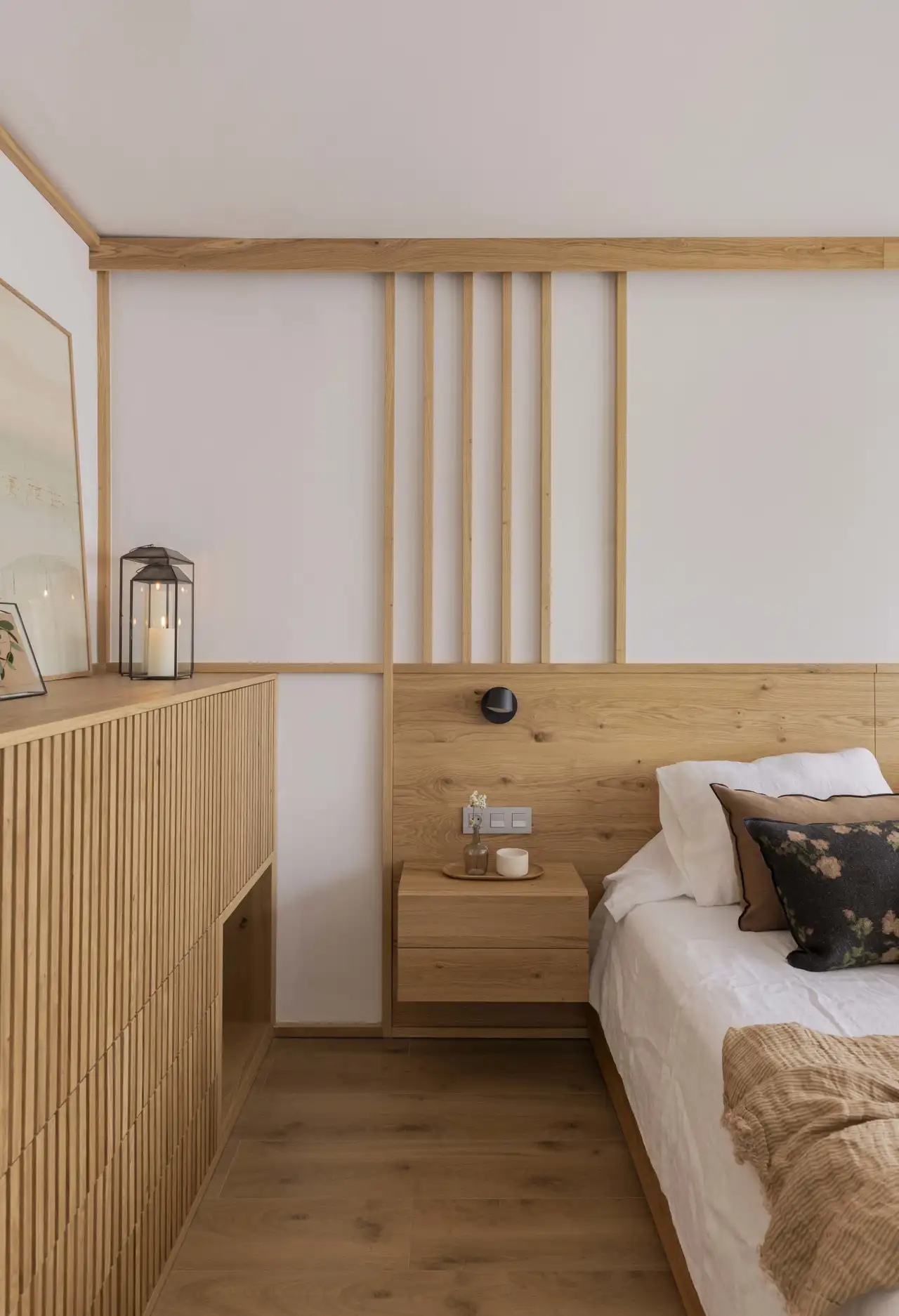 Los listones verticales de madera que decoran la pared del dormitorio siguen la misma idea estética que los del salón.