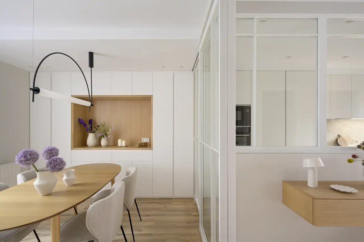 Un comedor conectado con la cocina con puertas correderas de cristal