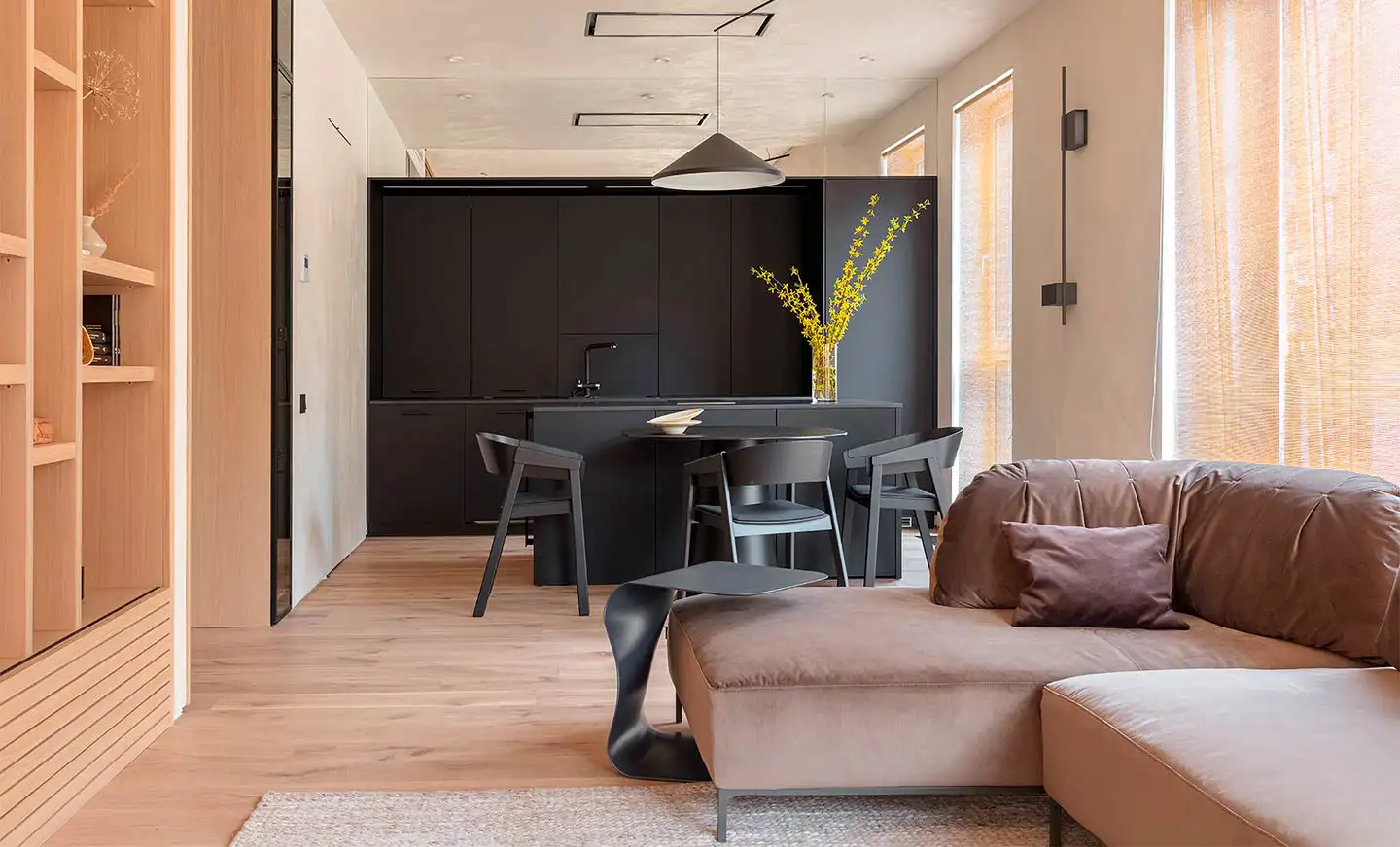 Una cocina de color negro y mucha madera, en esta casa de estilo Japandi