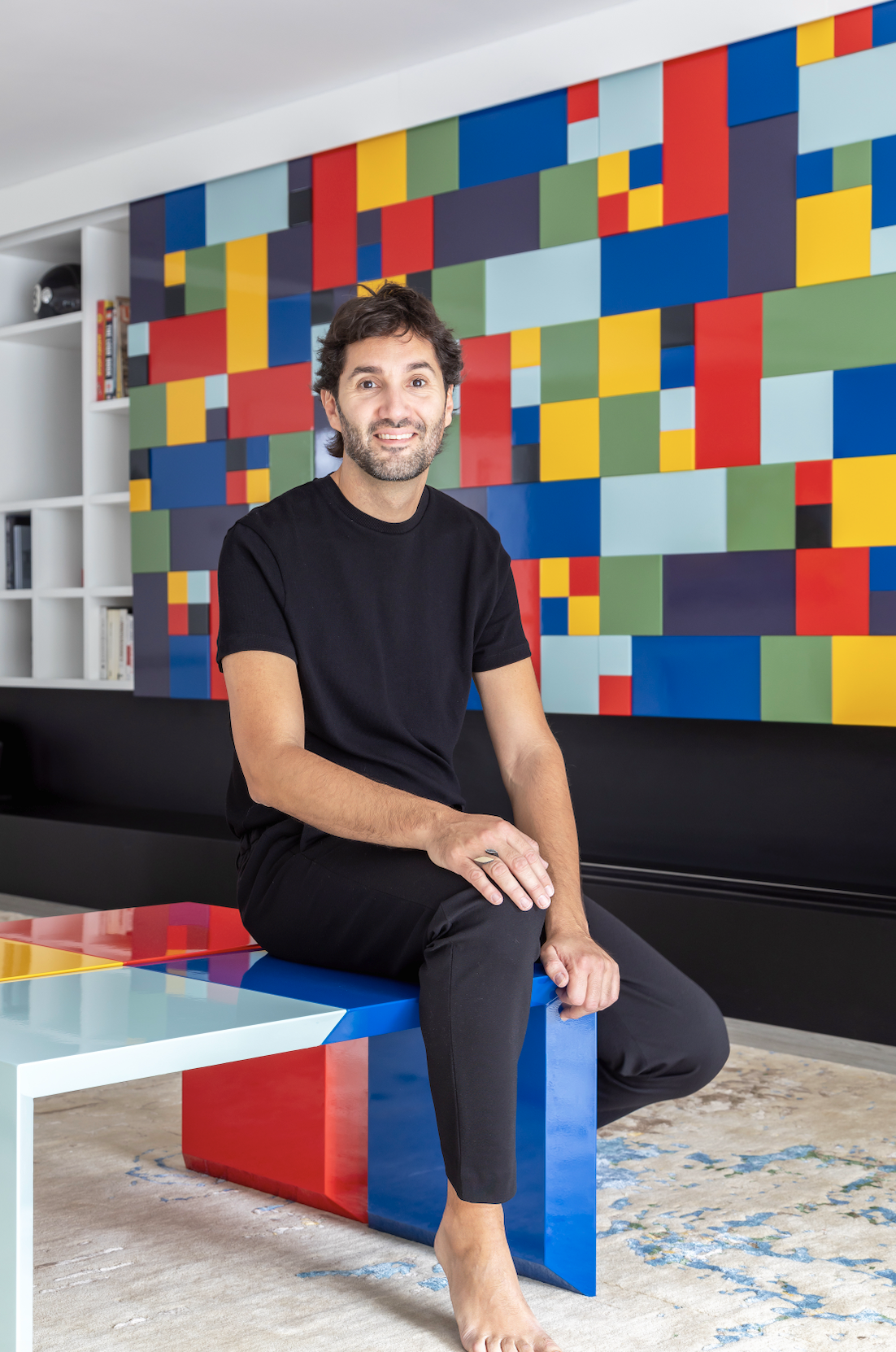 El autor del proyecto, Diego Guillén Ligori, posa sentado en la mesa de centro del salón, diseñada por él mismo para la marca Lignico.