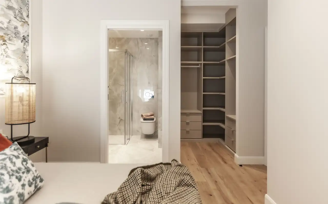 dormitorio en suite con baño y vestidor