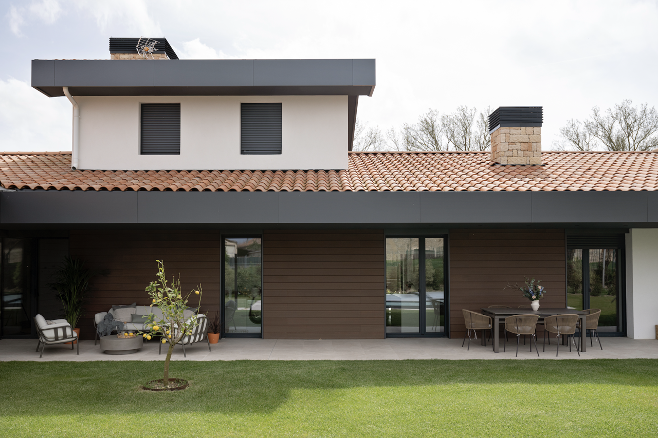 EXTERIORES. La vivienda cuenta con una amplia zona ajardinada y dos porches, cada uno diseñado para maximizar el disfrute en diferentes momentos del día.