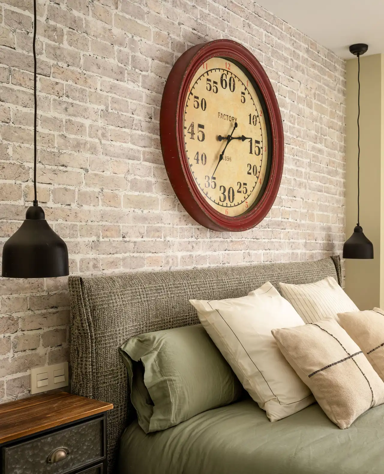 habitacion con papel pintado estilo ladrillo y gran reloj lamparas de metal y cabecero de tartán