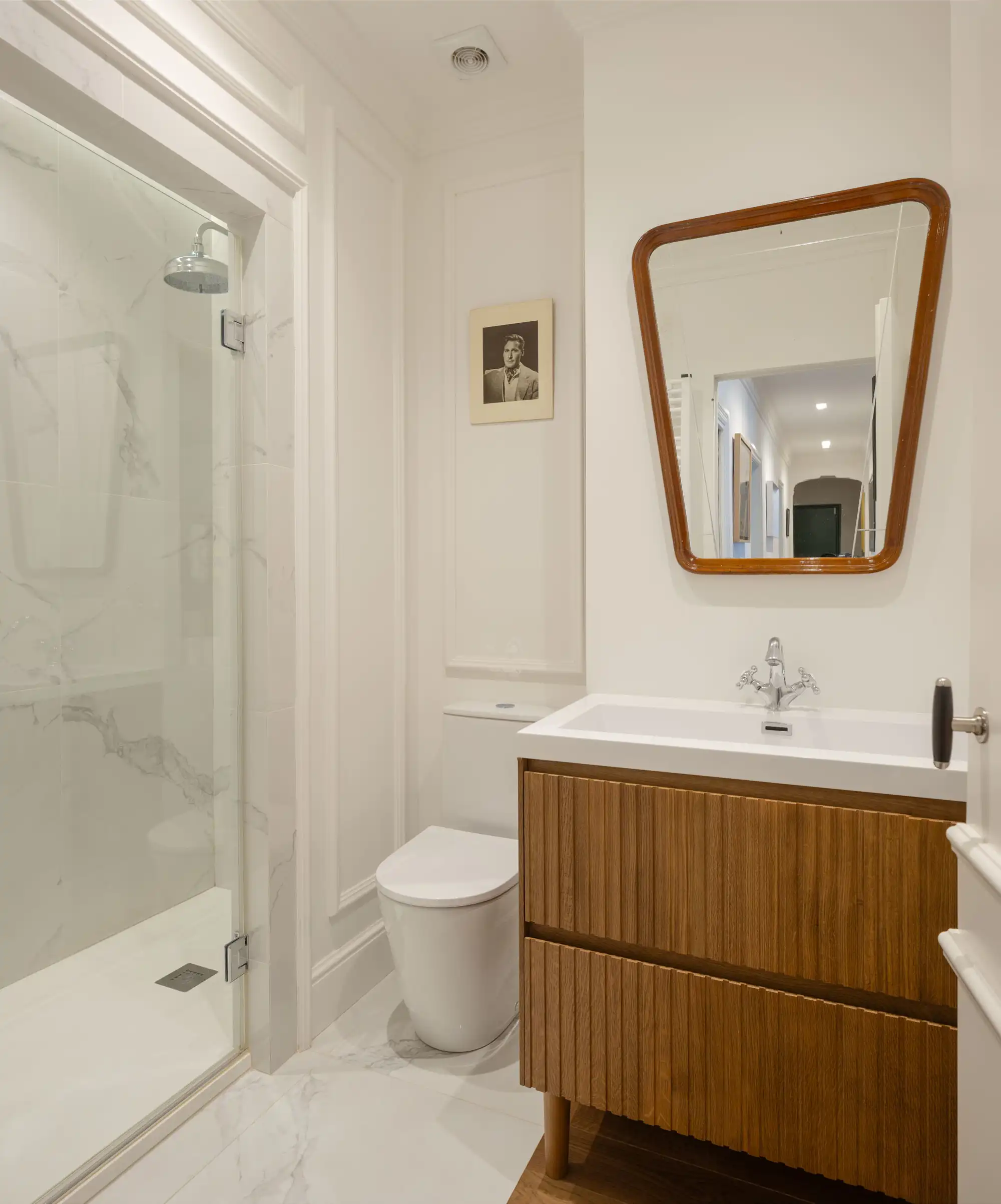 baño completo blanco con mueble y espejo de madera