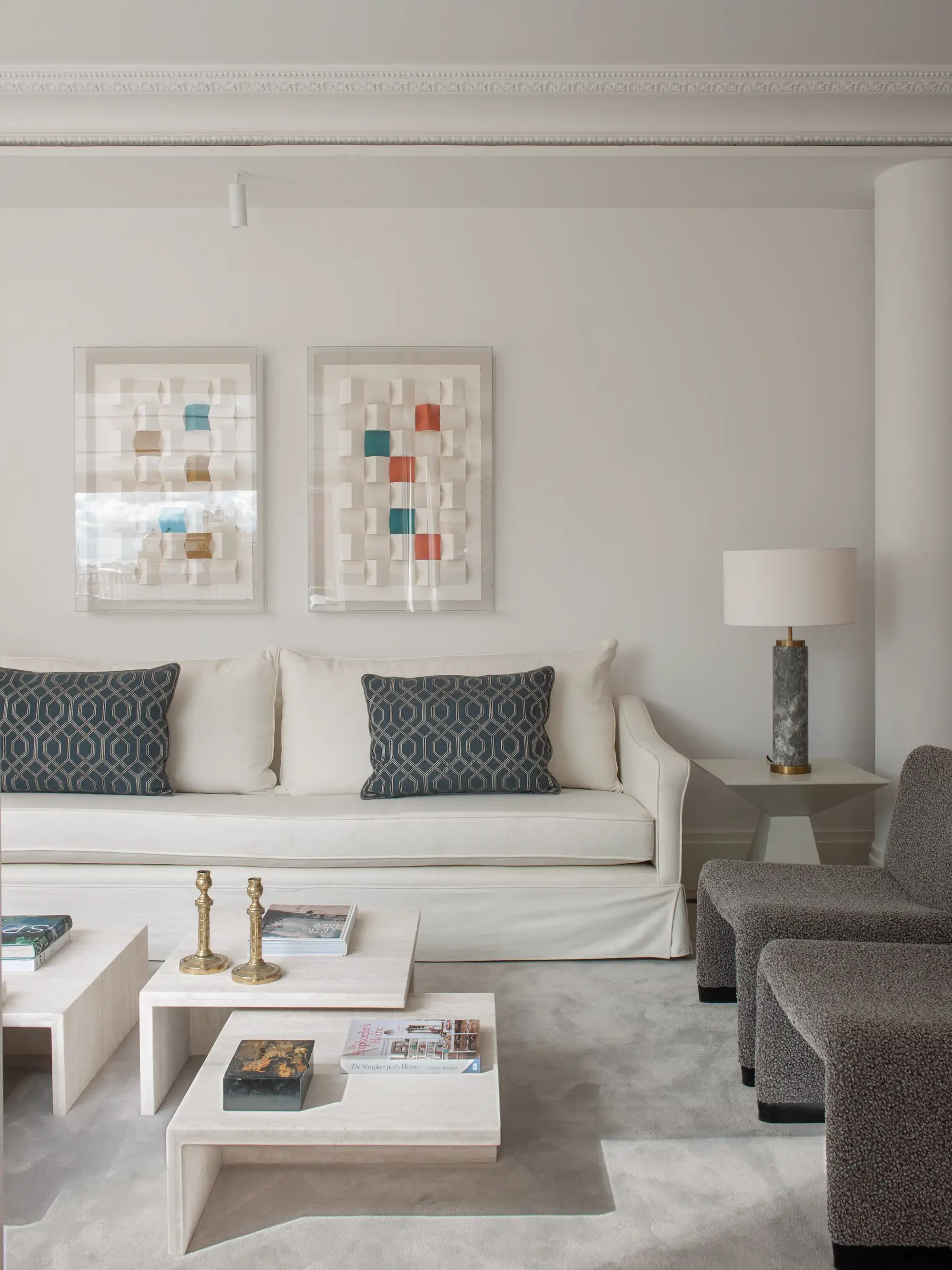 Salón con sofá blanco y pared de sofá con cuadros