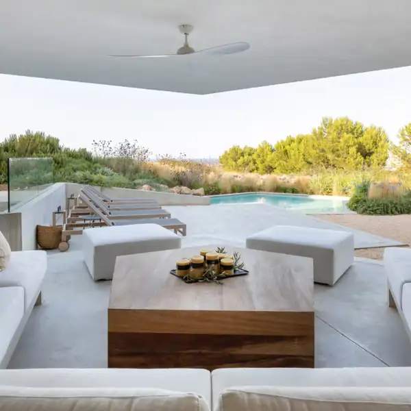 porche cubierto con jardin y piscina y sofas blancos