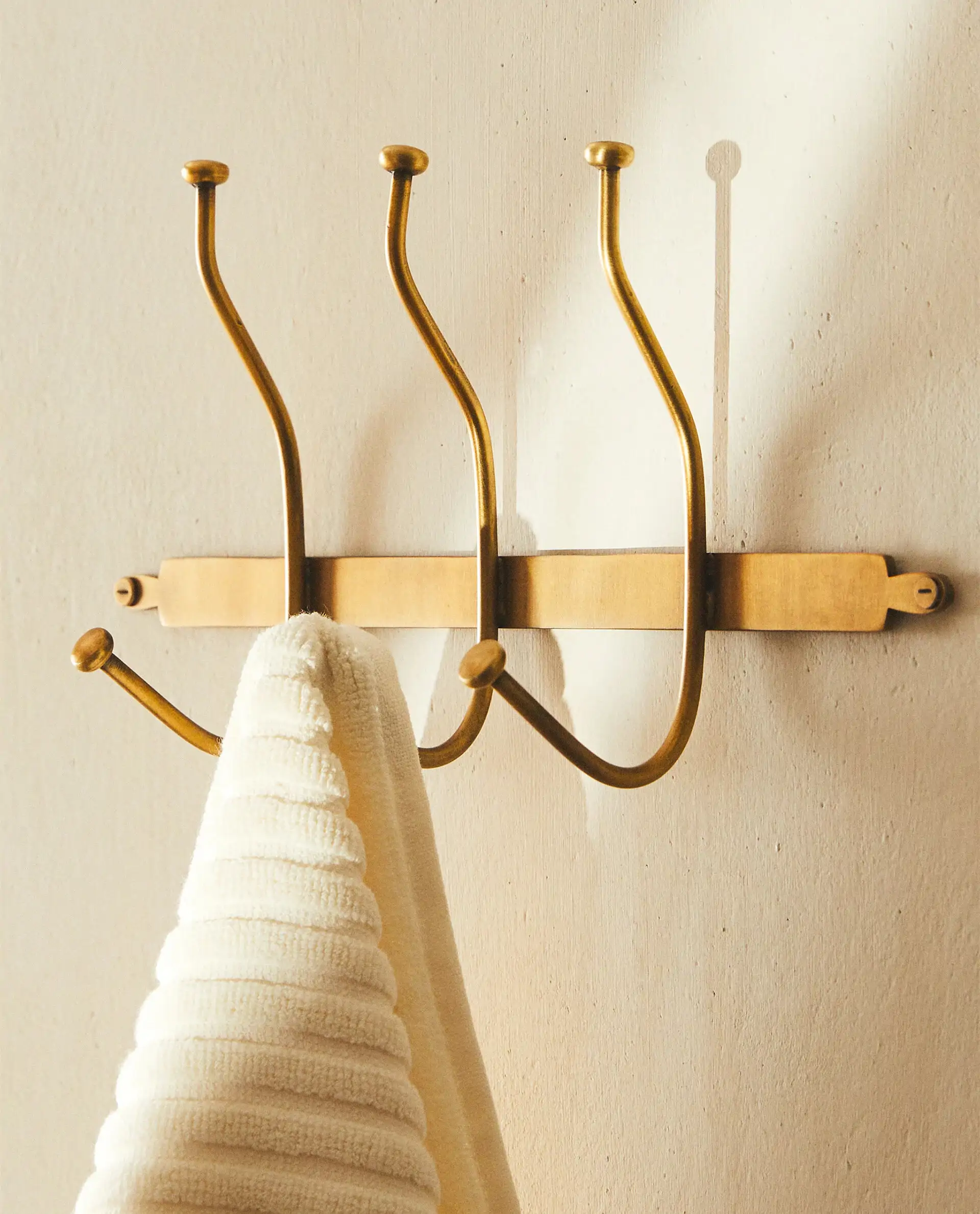 Perchero de pared acabado dorado