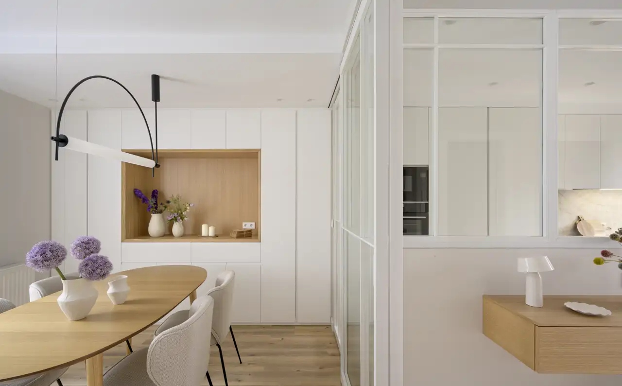 Un comedor conectado con la cocina con puertas correderas de cristal