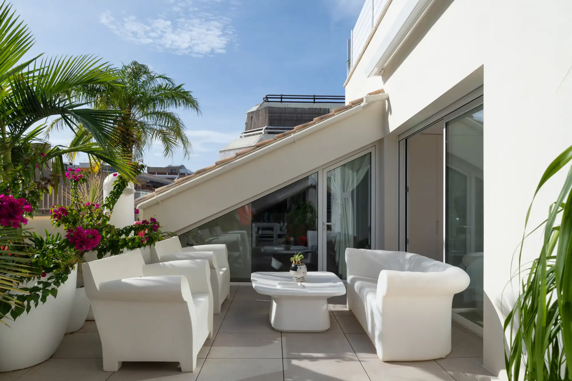 terraza atico techo inclinado mobiliario blanco