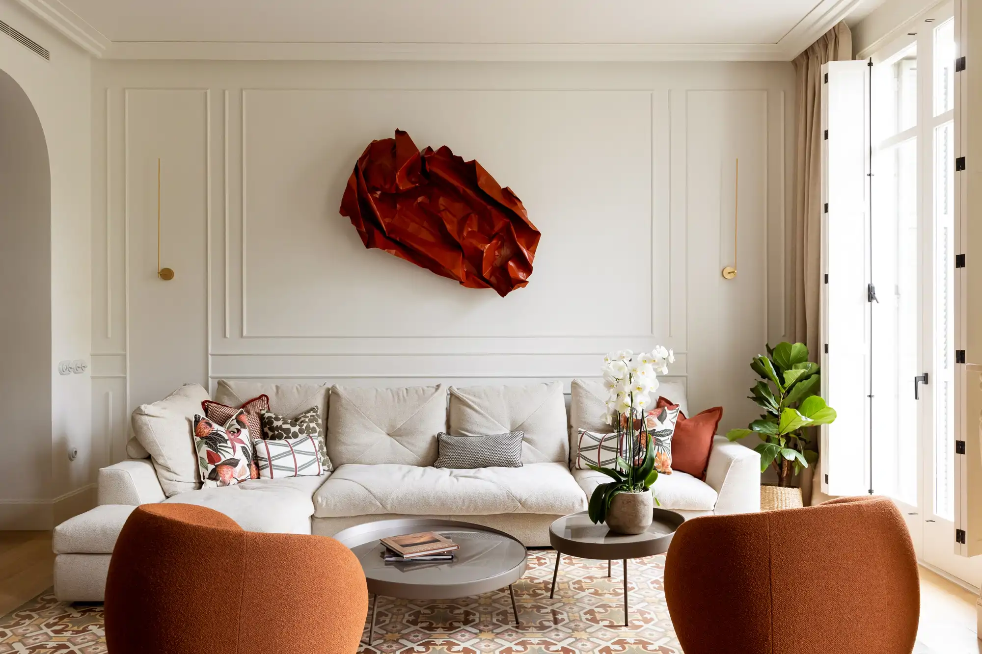 Salón con sofá blanco, suelo hidraúlico y escultura roja