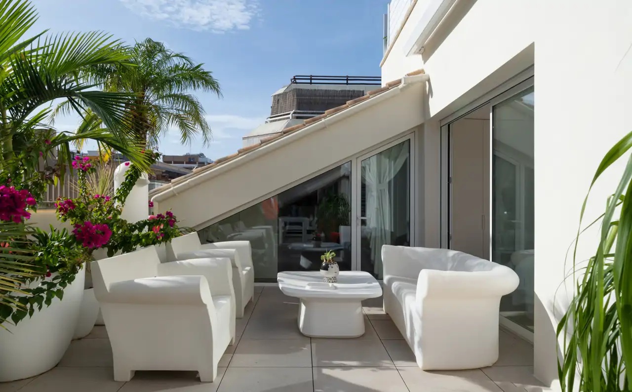 Una terraza en un ático con muchas plantas de exterior
