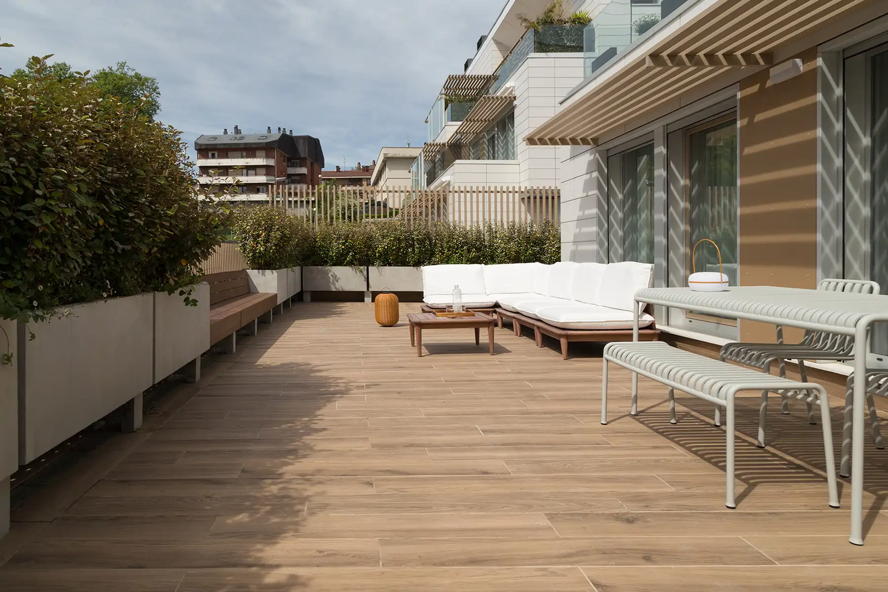 TERRAZA. Mobiliario comedor, de Hay. Zona de estar, de Kave Home. Jardineras-banco, diseñado por la arquitecta.