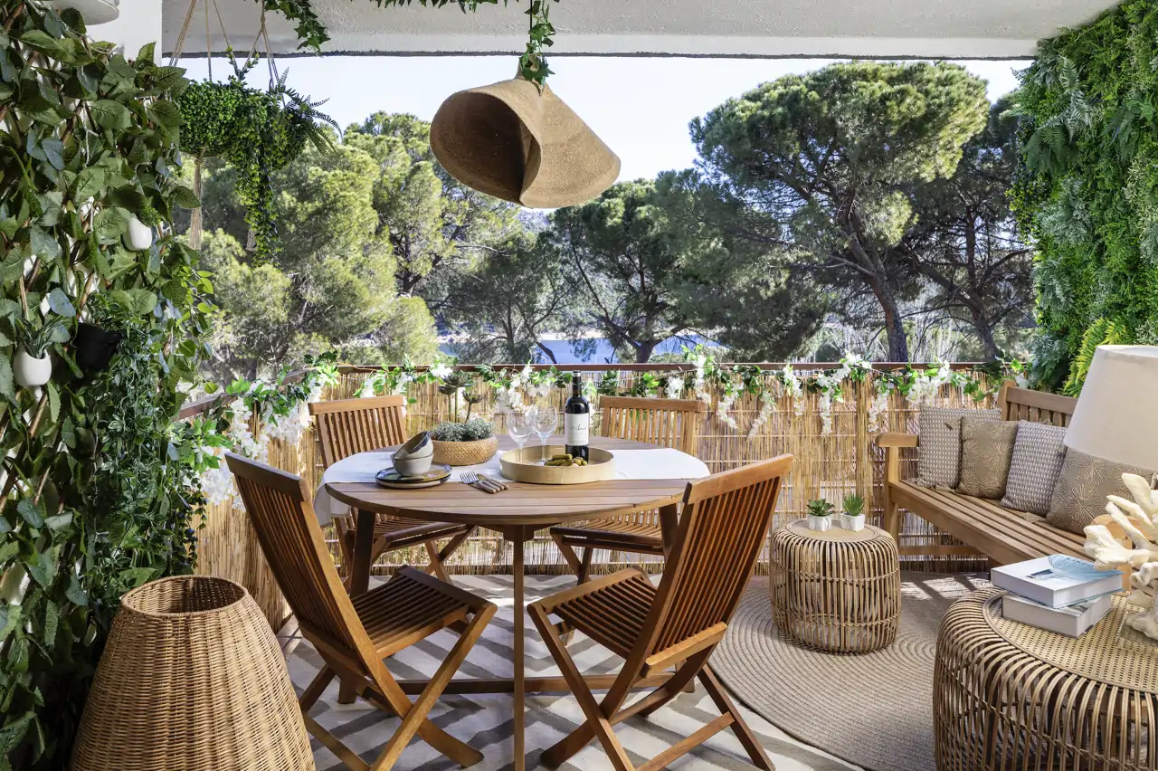 Una terraza generosa con muebles de madera y complementos de materiales naturales