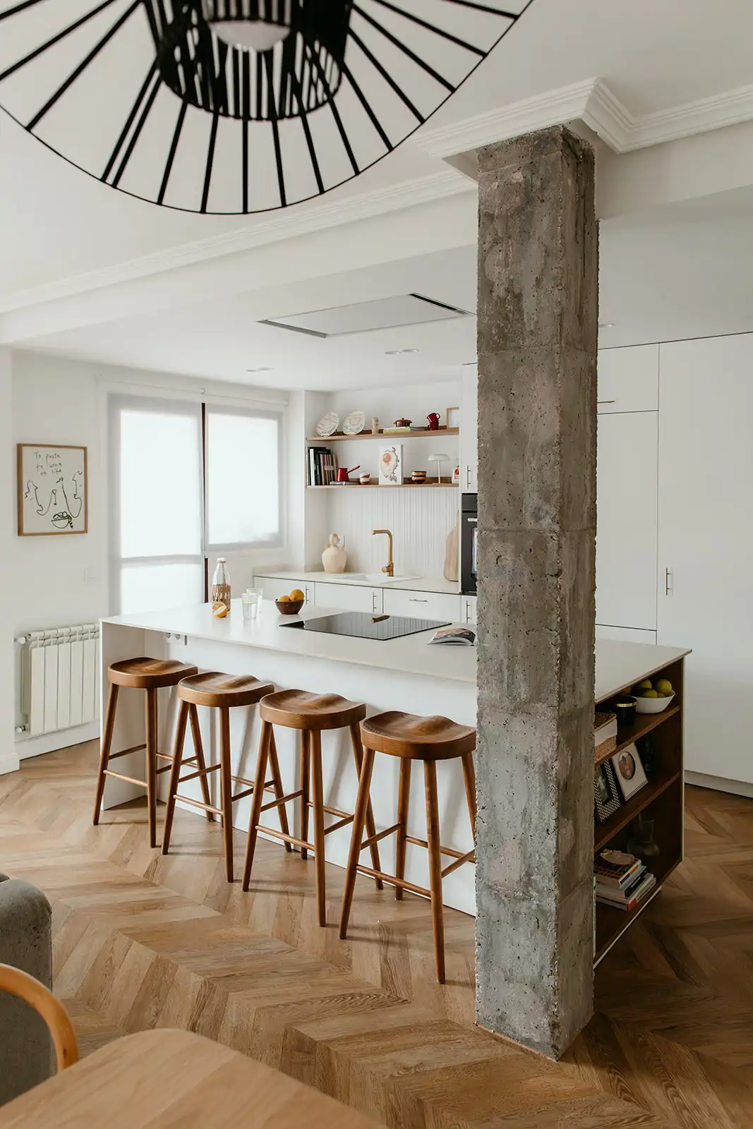 cocina abierta con isla central y columna hormigón