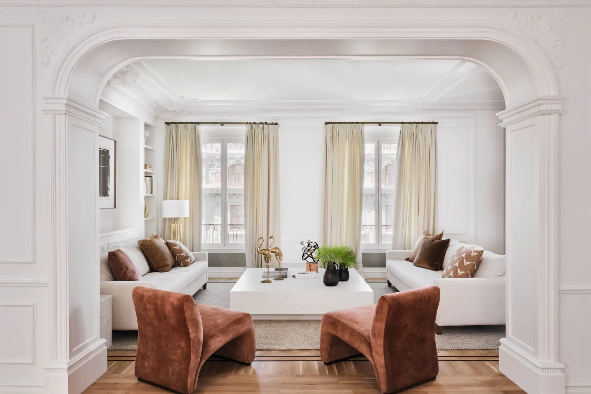 Salón clásico con sillones terracota y sofás blancos