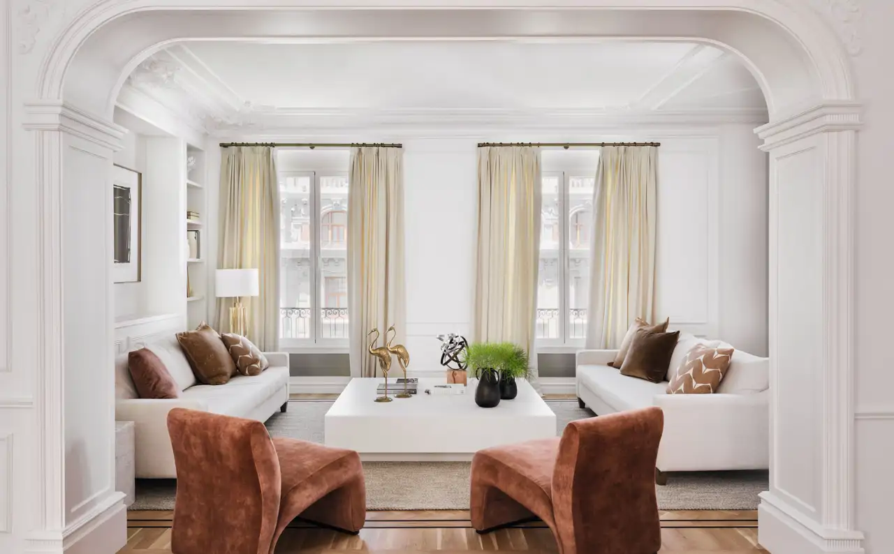 Salón clásico con sillones terracota y sofás blancos