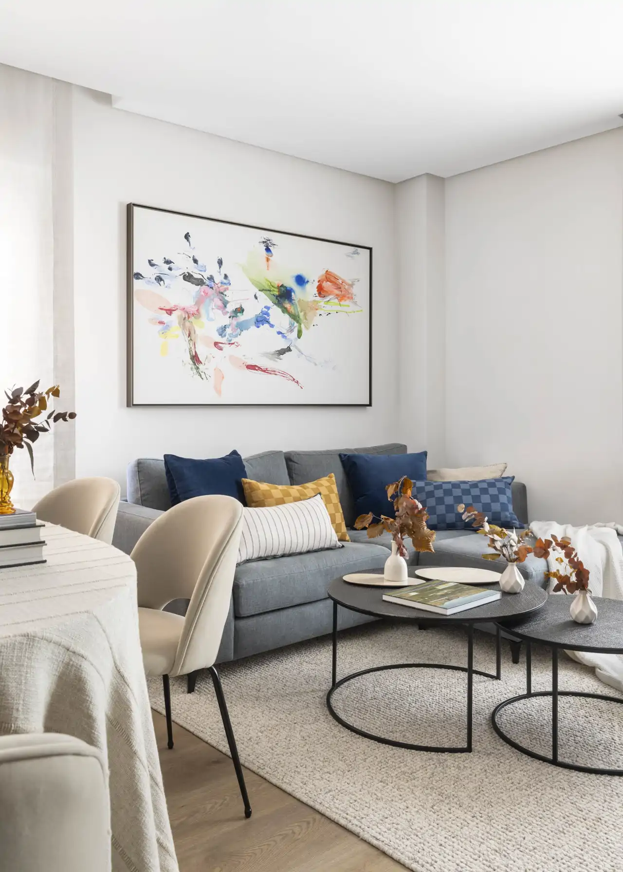 Salón blanco con sofá gris y obra de arte