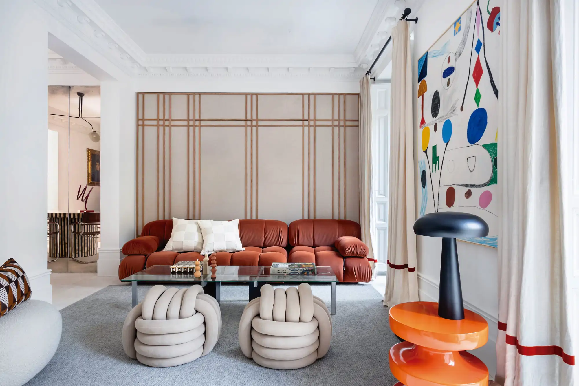 Salón con sofá rojo y pared con listones de madera