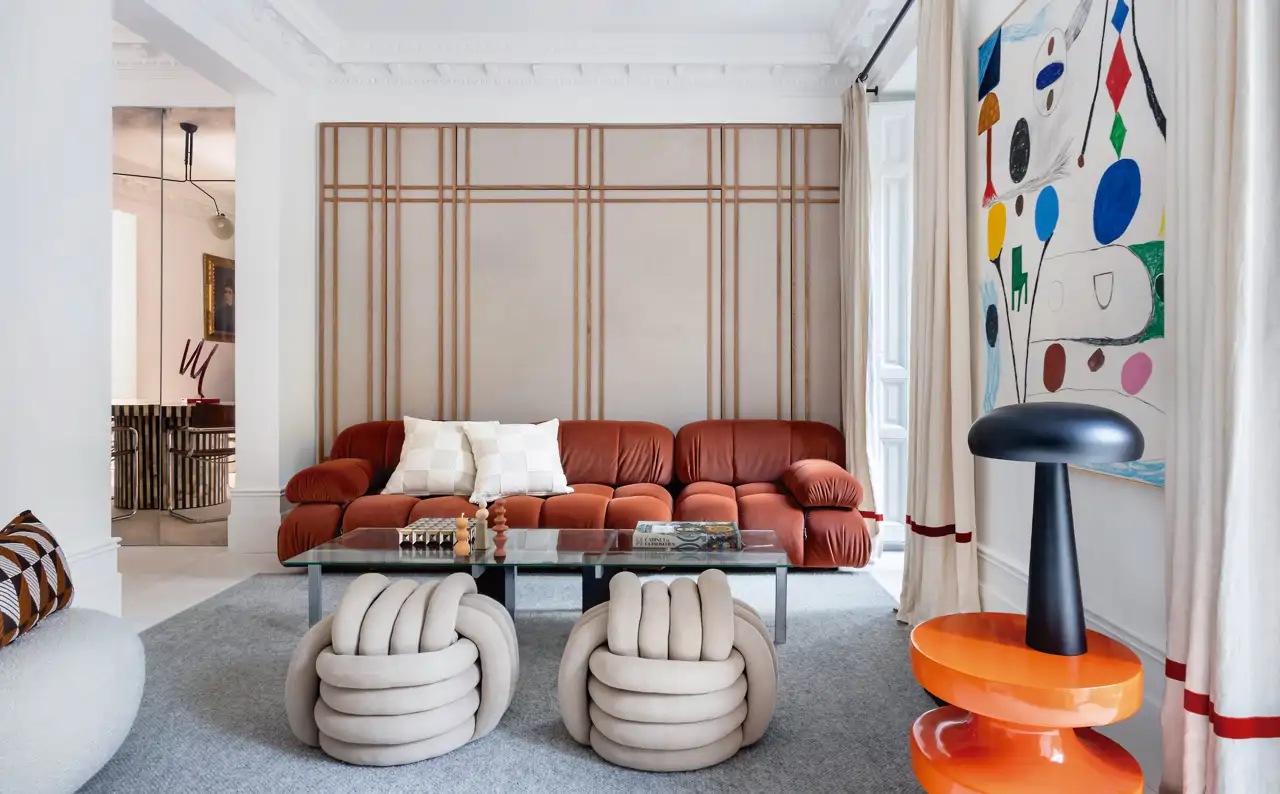 Salón con sofá rojo y pared con listones de madera