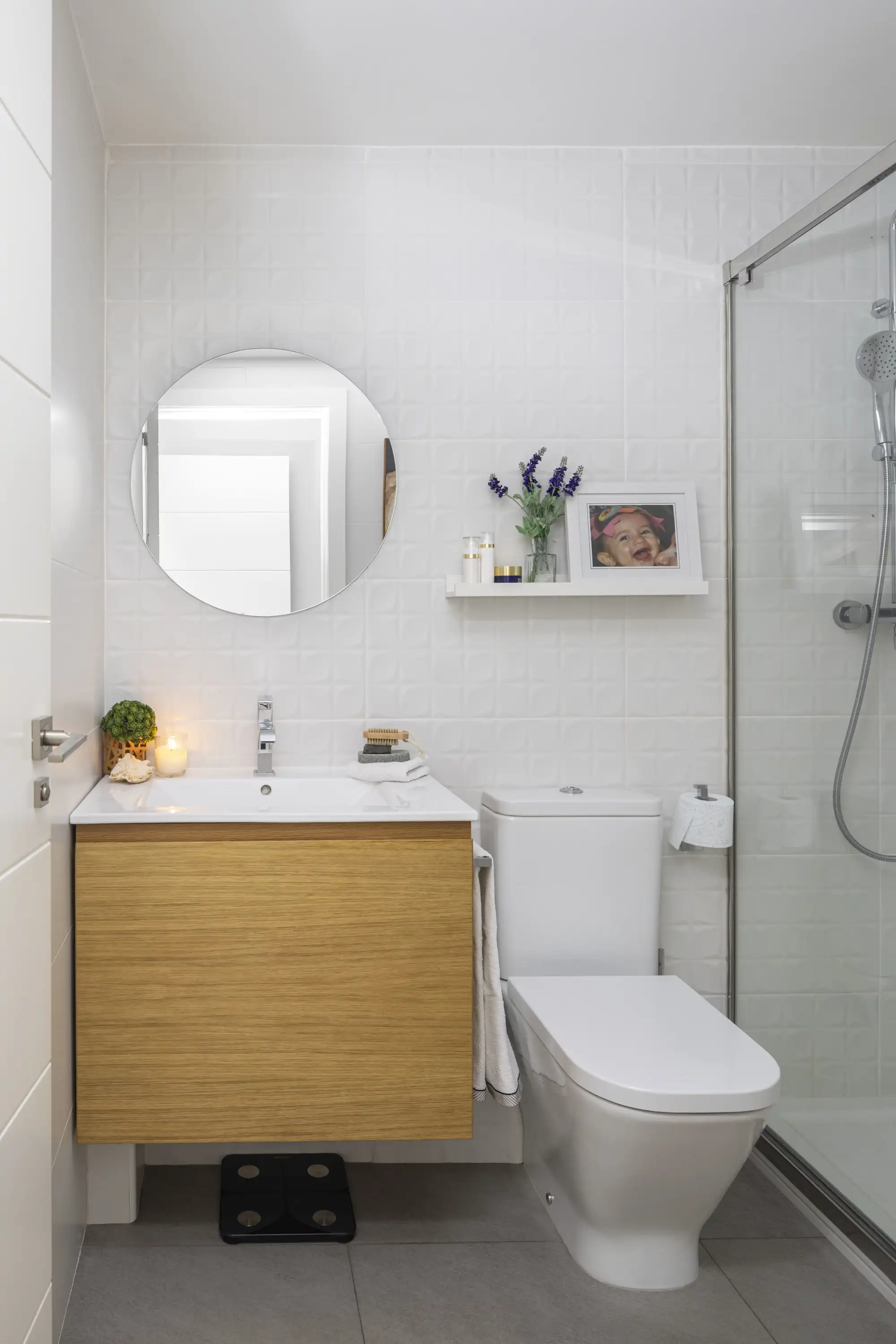 Un baño pequeño práctico y funcional con una estantería en la pared