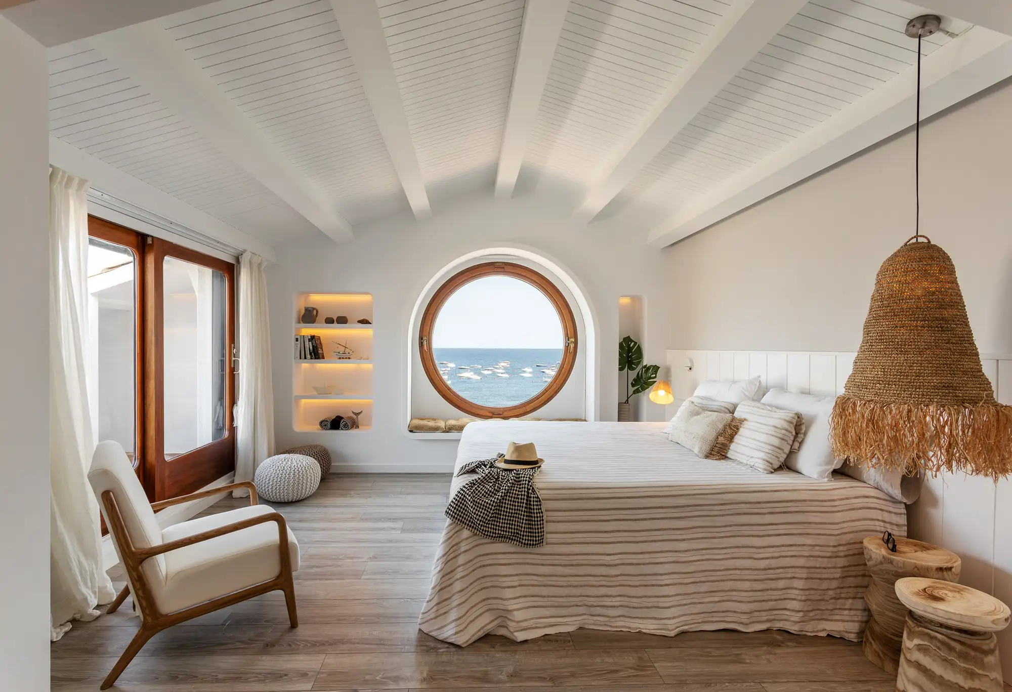 dormitorio vigas madera y ventana ojo de buey