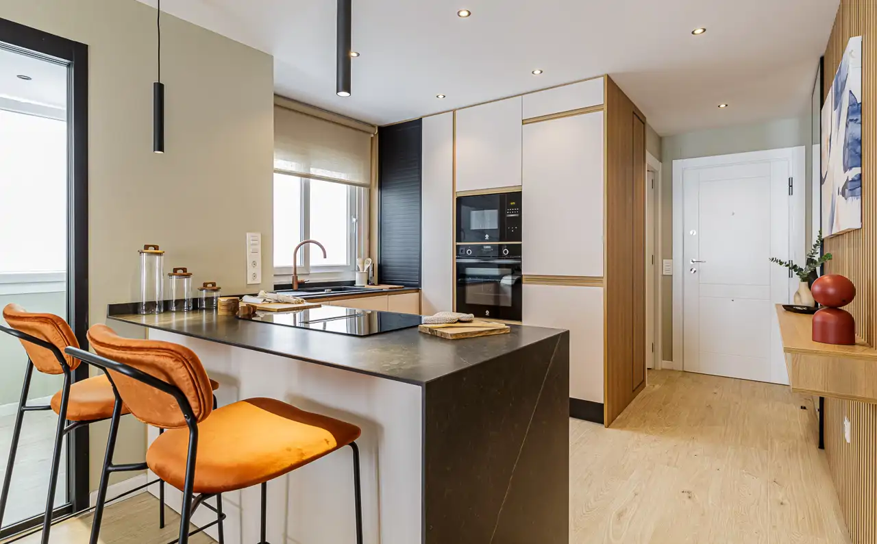 Una cocina con barra de desayuno en un pequeño apartamento