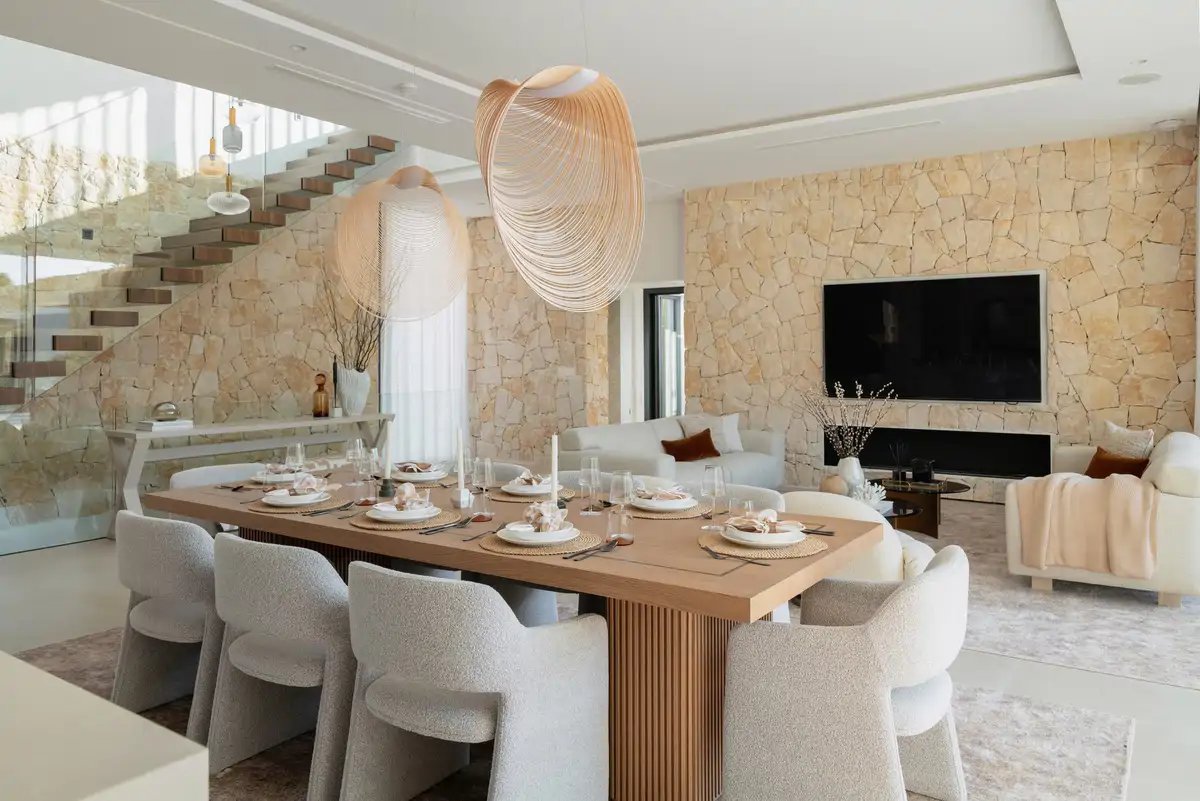 salon comedor con tonos neutros y pareces de piedra