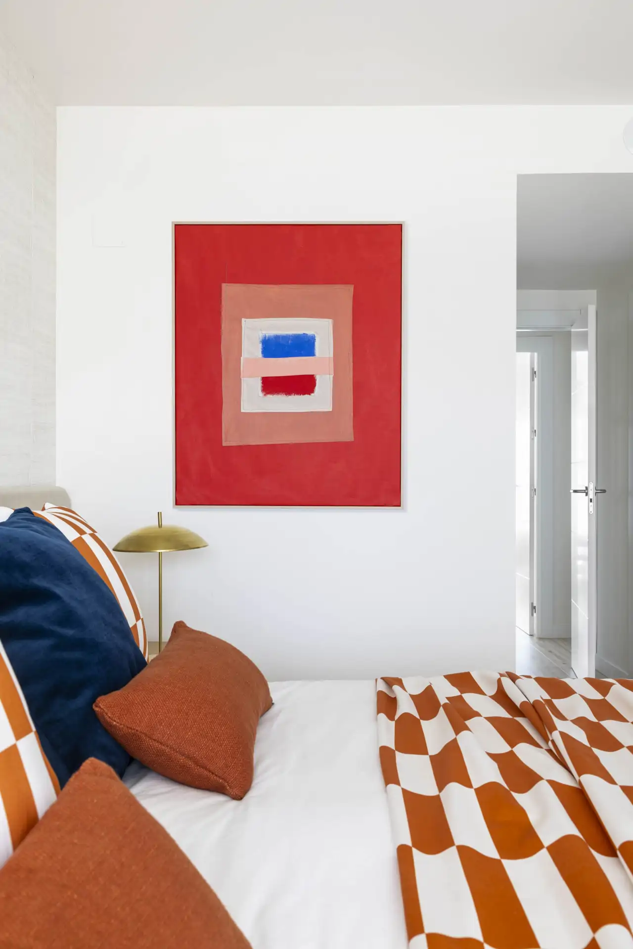 Habitación blanca con color cuadro y plaid naranja
