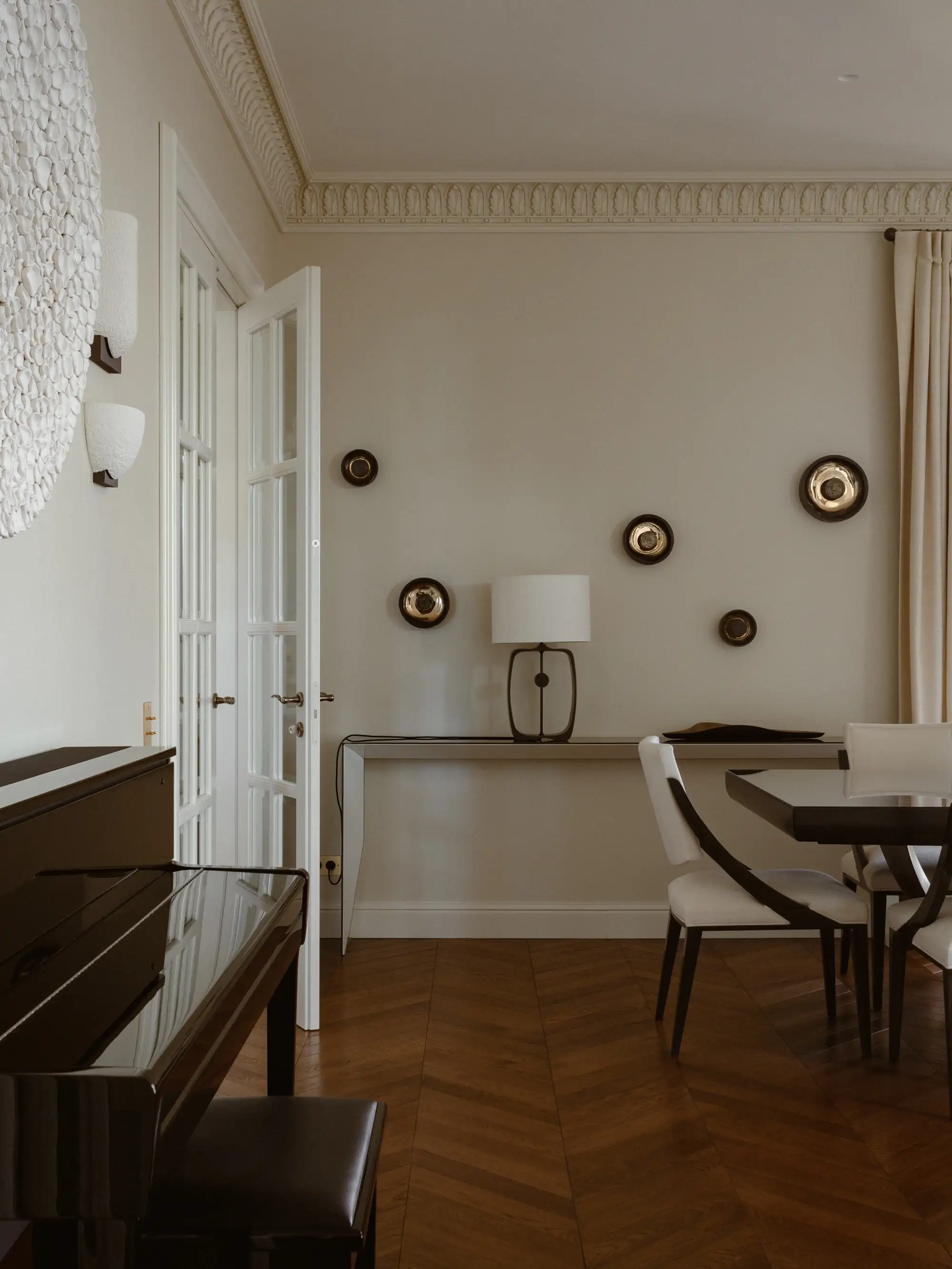 Comedor con piano, consola y paneles decorativos en la pared