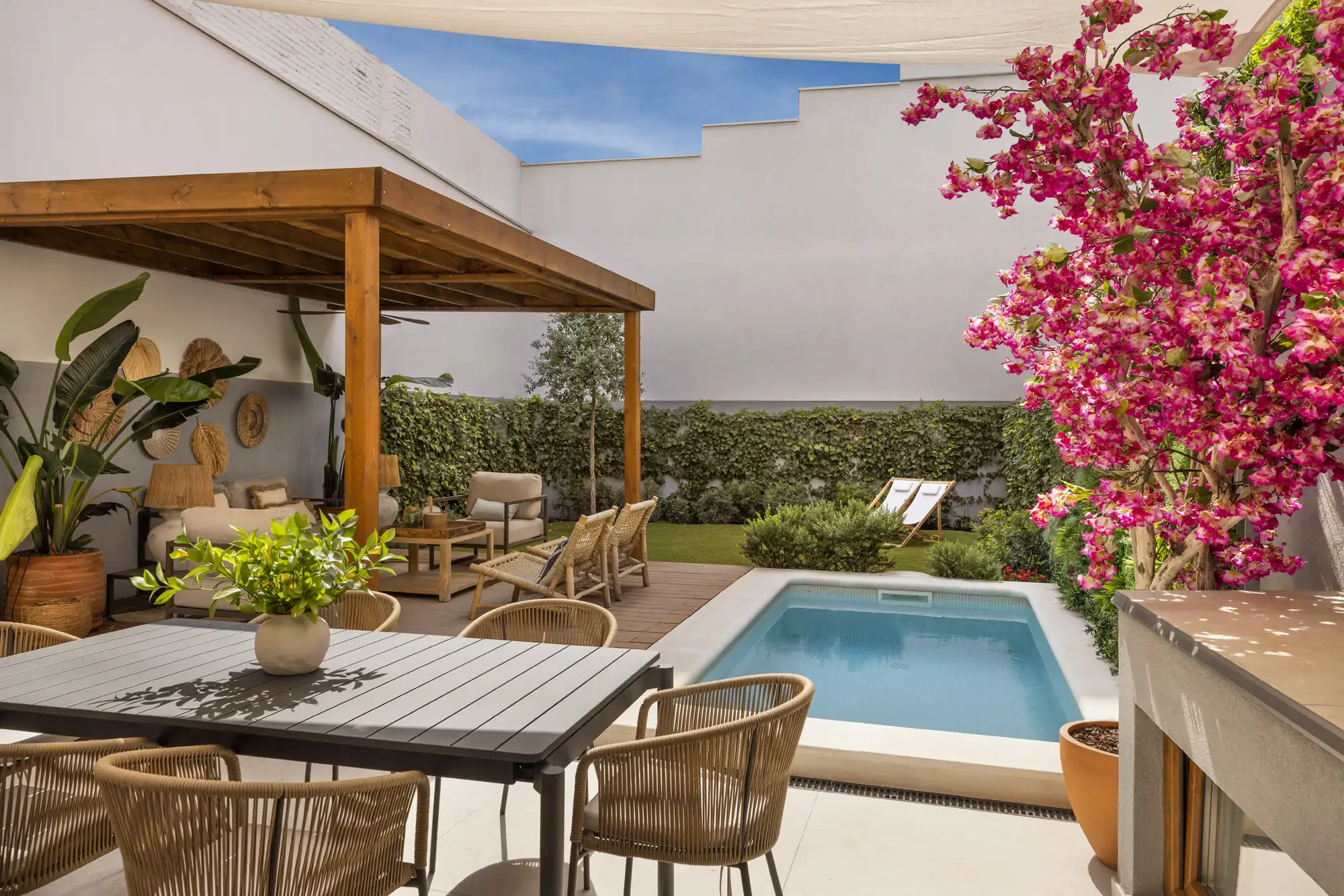 Un jardín exterior con piscina enterrada y comedor