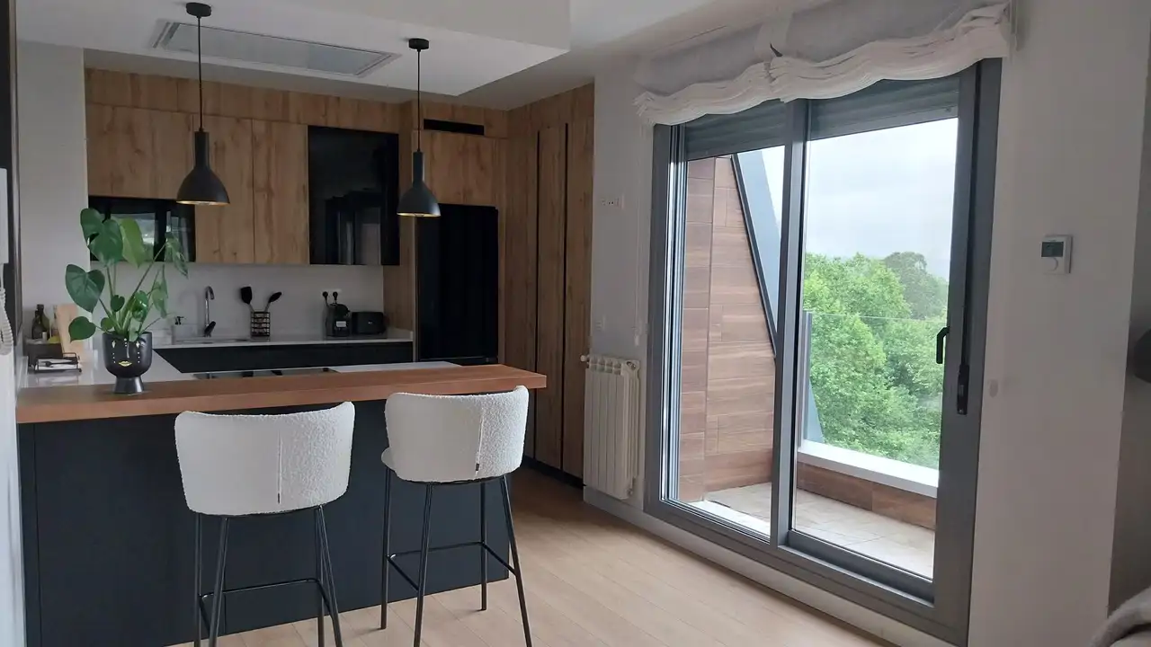 Una cocina en negro, madera y toques de luz