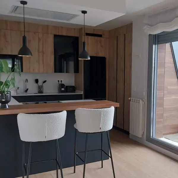 Una cocina en negro, madera y toques de luz