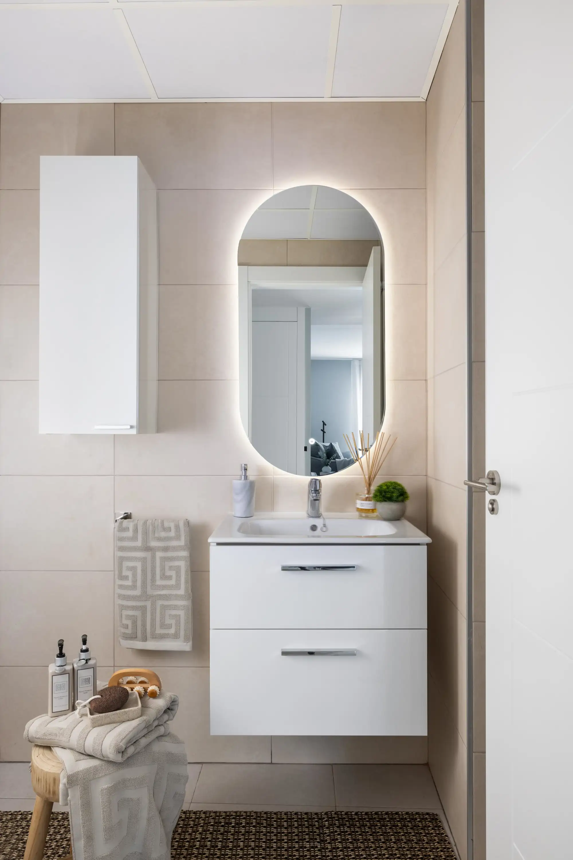 baño con espejo ovalado iluminado