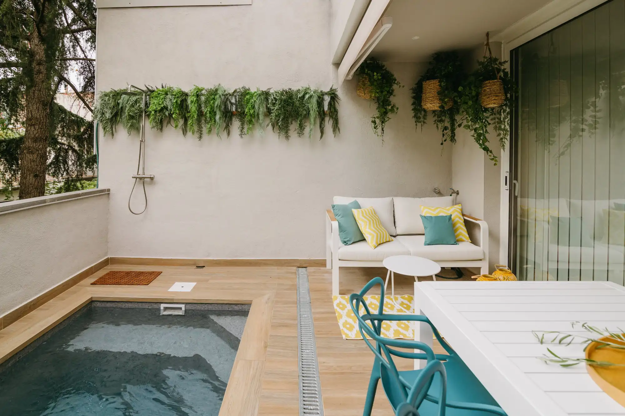 Una ducha mural exterior en una terraza con piscina
