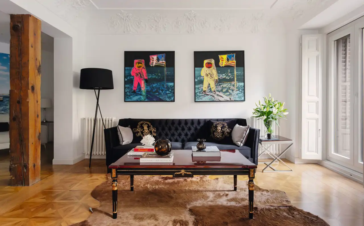 Salón con sofá chester oscuro y cuadros