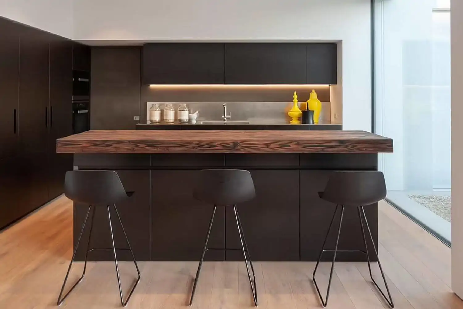 cocina negra con una isla que combina la madera oscura con el negro
