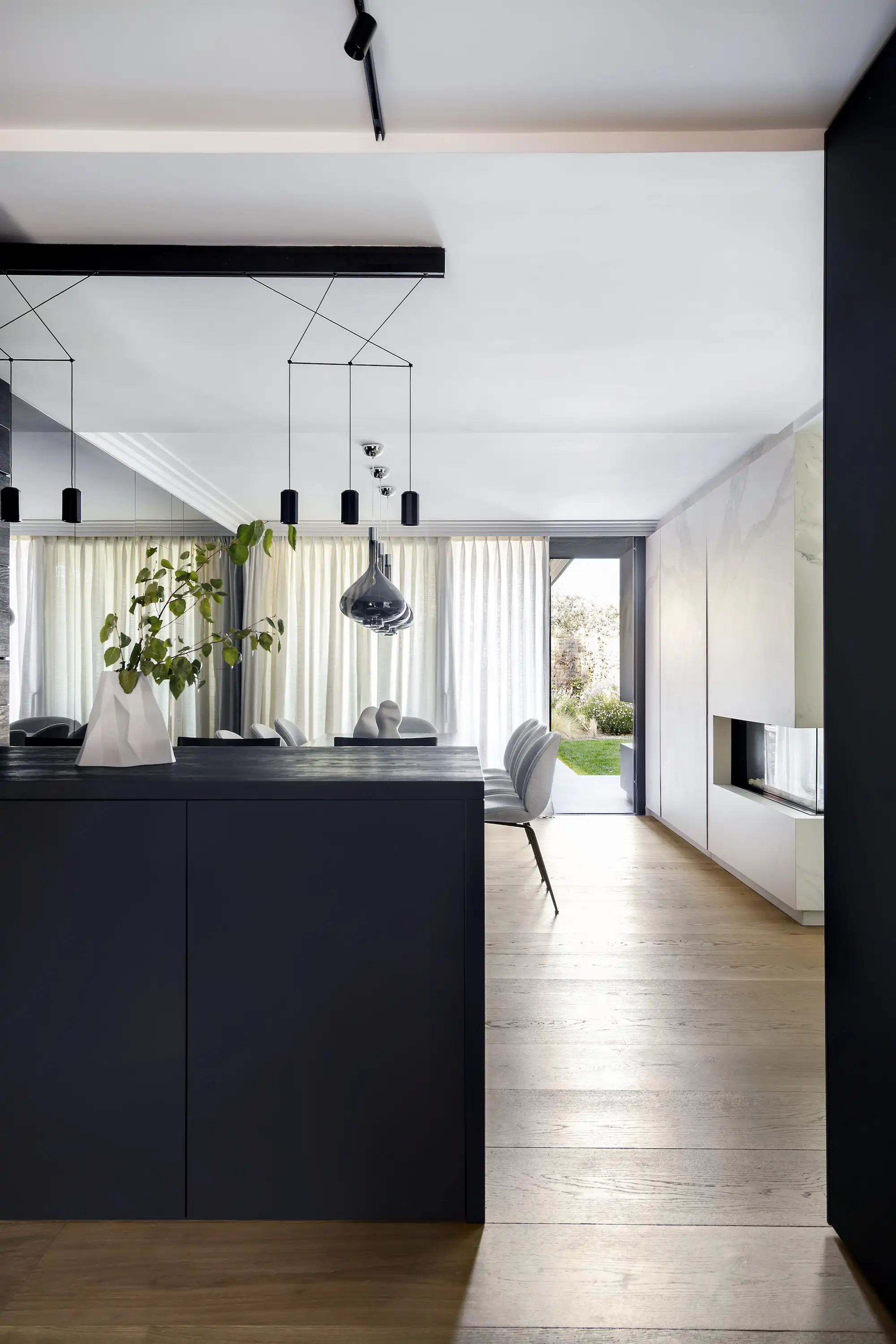 cocina negra abierta al comedor en tonos blancos 